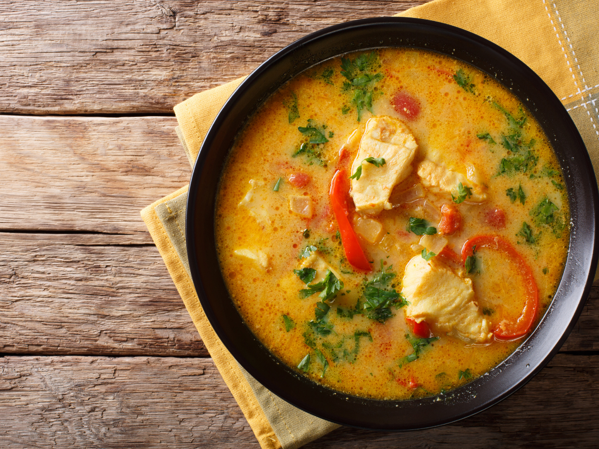 brightly colored Brazilian moqueca in black clay bowl